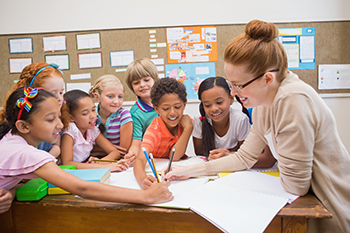 Kids working on a project together with a teacher.